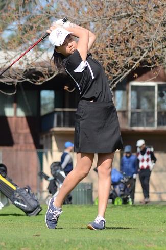 Girls golfer swinging club