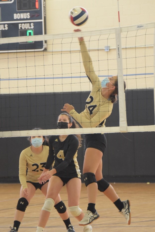 Girls volleyball player hitting ball